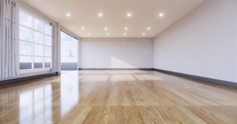 Empty room with a refinished hardwood floor.