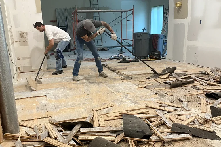 Two Men Removing Flooring with Hand Tools