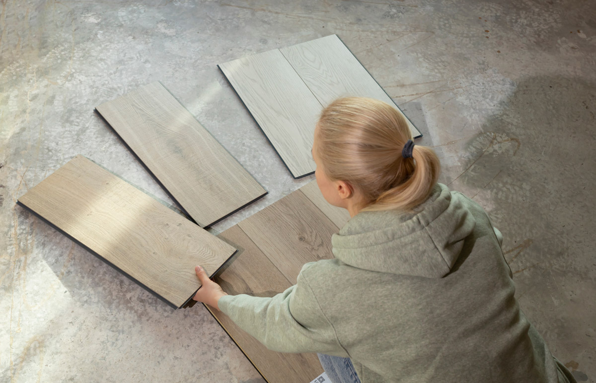 A woman compares flooring samples.