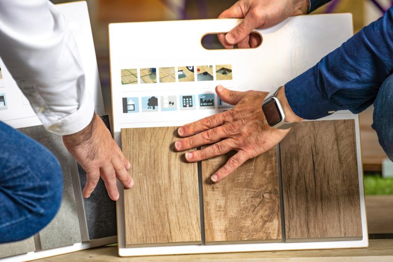 Two unseen men looking at flooring samples.